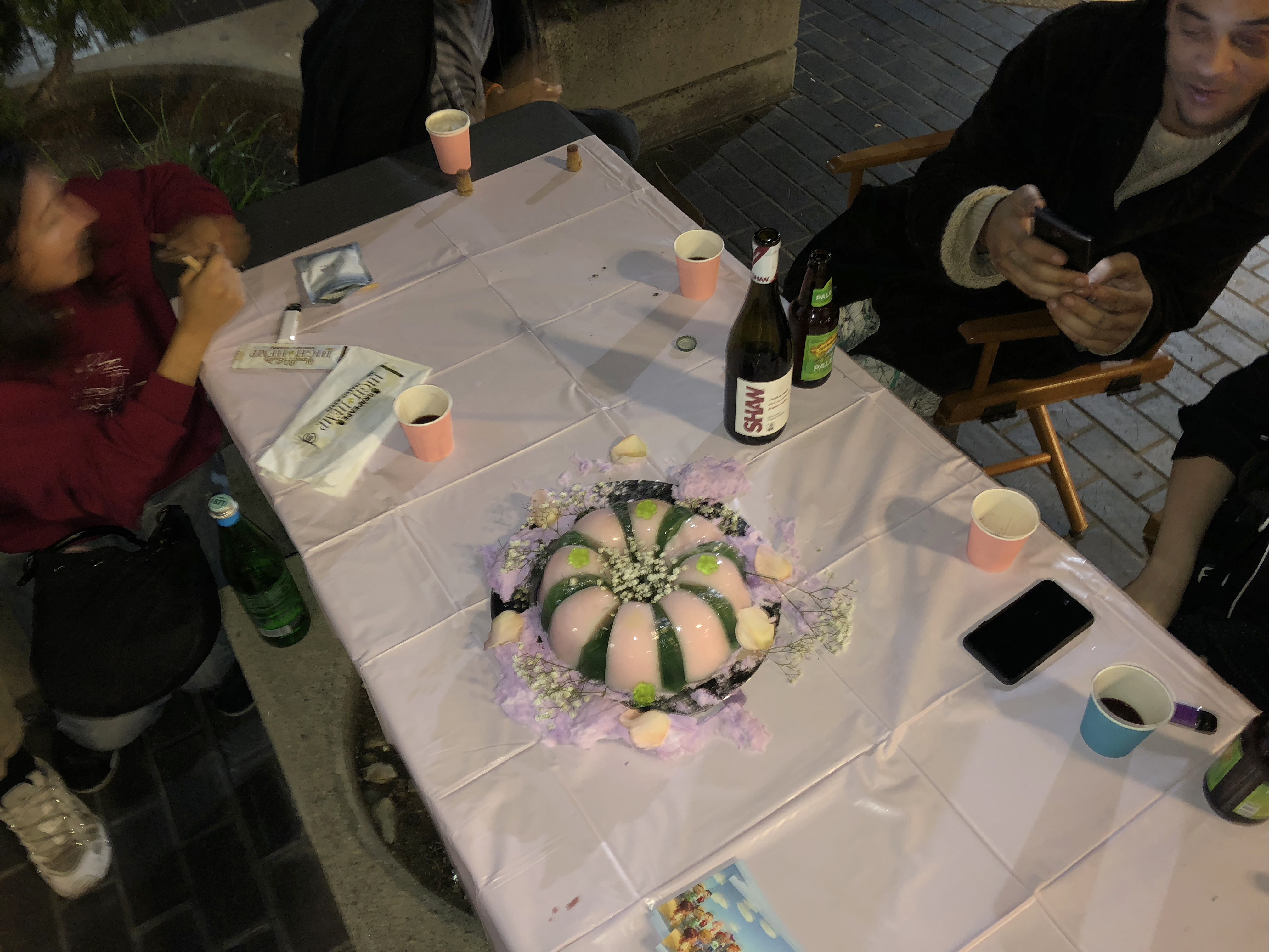 People sitting around a pink table drinking and talking